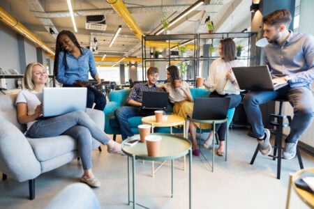 Digital marketing team members each working on their laptops in an agency office