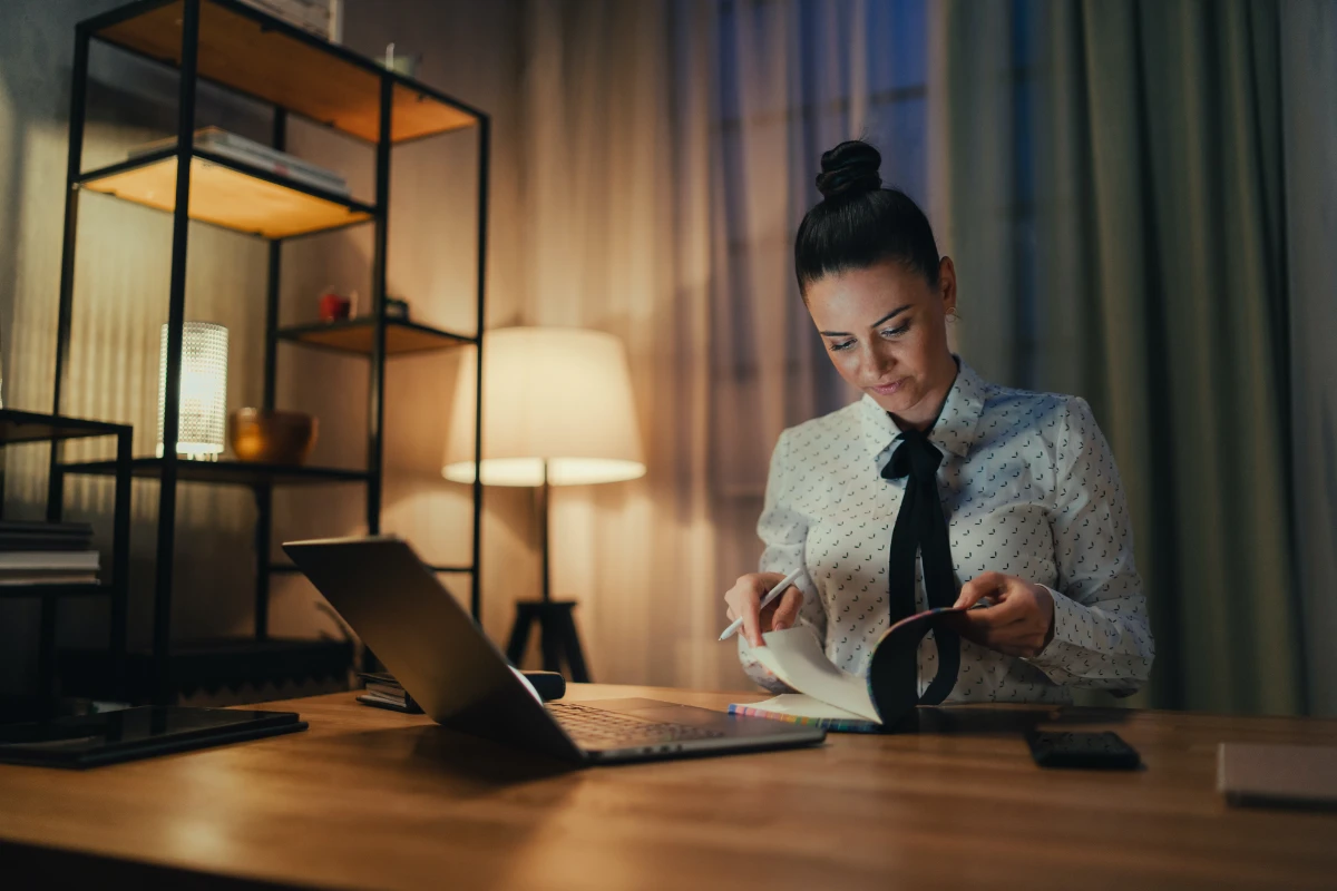 Online Marketing Manager working on a laptop and reading notes